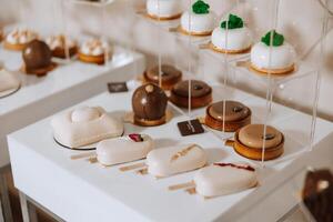 amêndoa biscoitos e vários doce bolos para uma Casamento banquete. uma delicioso recepção, uma luxuoso cerimônia. mesa com doces e sobremesas. delicioso colorida francês sobremesas em uma prato ou mesa. foto