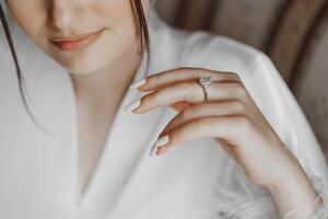 jovem noiva vestindo uma lindo Casamento anel, fechar-se. uma dourado Casamento anel em uma garotas dedo foto
