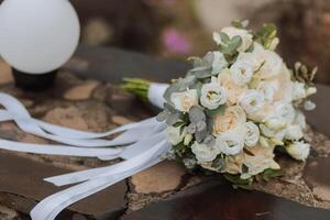 uma ramalhete do branco rosas carrinhos em uma de madeira fundo. cortada foto. detalhes às a casamento. foto