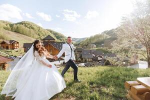 retrato do uma jovem noiva e noivo caminhando em verde Relva dentro uma ampla campo depois de a Casamento cerimônia, frente visualizar. feliz Casamento casal, cópia de espaço foto