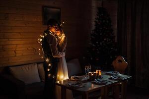 uma feliz noiva e noivo abraço dentro uma Sombrio quarto iluminado de desfocado luzes do uma festão foto