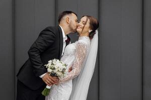 a noivo ternamente Beijos a noiva. jovem Casamento casal em seus Casamento foto