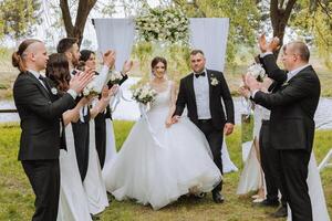 comprimento total retrato do a recém-casados e seus amigos às a casamento. a noiva e noivo com damas de honra e amigos do a noivo estão tendo Diversão e alegria às a casamento. foto