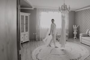 Casamento Preto e branco retrato. a noiva dentro a elegante Casamento vestir poses embrulhado dentro uma véu. manhã do a noiva. lindo cabelo e Maquiagem foto