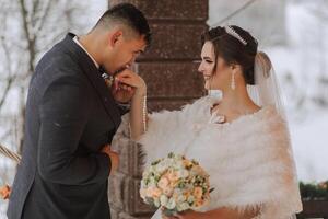 feliz casal se beijando dentro inverno. casal abraçando dentro Nevado inverno park.winter Casamento do à moda lindo jovem casal noiva e noivo foto