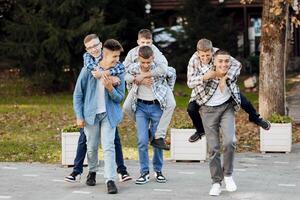 uma grupo do adolescentes ter Diversão e alegrar, corrida dentro a parque. Adolescência colegas de classe estão em repouso contra a fundo do outono natureza. foto