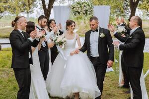 comprimento total retrato do a recém-casados e seus amigos às a casamento. a noiva e noivo com damas de honra e amigos do a noivo estão tendo Diversão e alegria às a casamento. foto