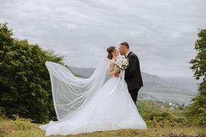 casamento. amor e casal dentro jardim para casamento. celebração do cerimônia e compromisso. Salve  a data. Confiar em a noivo abraços a noiva dentro a montanhas em a fundo do a floresta foto