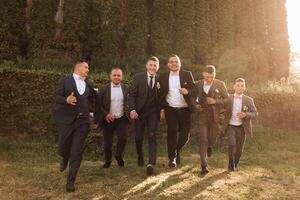 alegre, jovem, enérgico testemunhas do a noivo Próximo para a noivo. amigos felicitar a noivo. noivo e dele engraçado amigos tendo Diversão em a Casamento dia do a recém-casados. foto