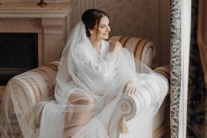 uma luxuoso noiva dentro uma Casamento vestir dentro a manhã dentro dela interior. foto
