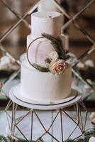branco real Casamento bolo decorado com flores em uma dourado ficar em pé. real casamento, doces foto