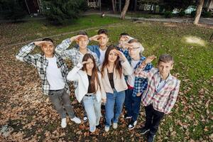 amizade, movimento, Ação, liberdade e pessoas conceito - grupo do feliz adolescentes ou escola amigos posando e tendo Diversão ao ar livre contra natureza ou floresta fundo. foto