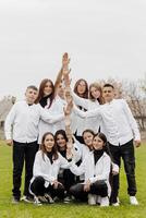 uma grupo do muitos feliz adolescentes vestido dentro a mesmo equipamento tendo Diversão e posando dentro uma estádio perto uma faculdade. conceito do amizade, momentos do felicidade. escola amizade foto