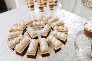 doce Barra para uma casamento. doce Barra em pé festivo mesa com sobremesas, bolos de copo e macarons. lindo e saboroso. foto
