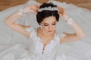 lindo noiva dentro uma luxuoso Casamento vestir com uma elegante Casamento Penteado, profissional inventar. fechar-se retrato do jovem linda noiva dentro quarto a partir de manhã. Alto qualidade foto. foto