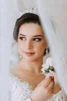 lindo noiva dentro uma luxuoso Casamento vestir com uma elegante Casamento Penteado, profissional inventar. fechar-se retrato do jovem linda noiva dentro quarto a partir de manhã. Alto qualidade foto. foto