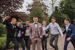 alegre, jovem, enérgico testemunhas do a noivo Próximo para a noivo. amigos felicitar a noivo. noivo e dele engraçado amigos tendo Diversão em a Casamento dia do a recém-casados. foto