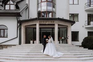 retrato do a recém-casados dentro clássico Casamento roupas em uma ampla lindo Escadaria. a conceito do lojas e vendas do bens para a noiva e noivo. foto