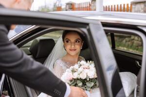 uma lindo noiva, sentado dentro uma carro, parece Fora do a aberto janela do a carro. uma lindo noiva com uma ramalhete do flores dentro dela mãos é sentado dentro uma à moda caro carro. foto