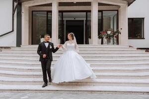 retrato do a recém-casados dentro clássico Casamento roupas em uma ampla lindo Escadaria. a conceito do lojas e vendas do bens para a noiva e noivo. foto