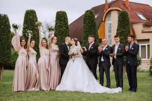 comprimento total retrato do a recém-casados e seus amigos às a casamento. a noiva e noivo com damas de honra e amigos do a noivo estão tendo Diversão e alegria às a casamento. foto