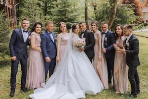 comprimento total retrato do a recém-casados e seus amigos às a casamento. a noiva e noivo com damas de honra e amigos do a noivo estão tendo Diversão e alegria às a casamento. foto