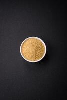 trigo mingau cuscuz grãos em uma Sombrio concreto fundo foto