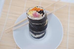 Sushi rolos em uma prato em uma branco fundo. japonês Comida foto