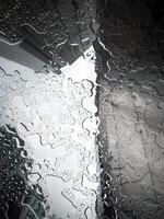 gotas do chuva em a escritório janela. borrão urbano Horizonte fundo. chuvoso estação conceitos. foto