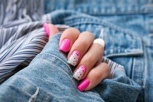 lindo fêmea mãos com uma manicure em uma jeans fundo. sombreado unha Projeto. verão manicure. cópia de espaço. foto