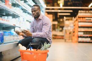 atraente africano americano homem compras dentro uma supermercado foto