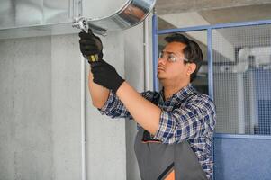 hvac indiano trabalhador instalar canalizado tubo sistema para ventilação e ar condicionamento. cópia de espaço foto