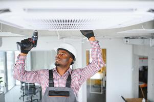 africano masculino técnico reparação ar condicionador. foto