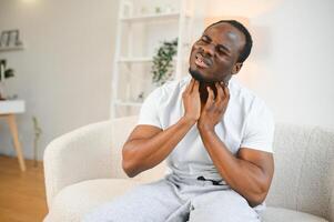 doente africano homem com dolorido garganta, retrato do eu vou Preto homem sofrimento a partir de dolorido garganta vencimento para frio, gripe, alergia foto