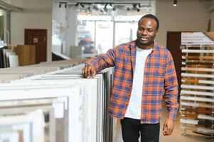 africano americano homem escolhendo azulejos às construção mercado foto
