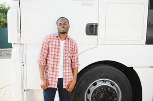 retrato africano masculino feliz sorridente confiante positivo perto caminhão. jovem homem xadrez camisa proprietário caminhão motorista dentro o negócio grandes transporte polegares acima satisfeito serviço comercial dirigindo licença Treinamento foto