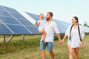 feliz família perto solar painéis. alternativo energia fonte foto