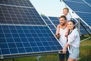a conceito do verde energia. feliz família caminhando e tendo Diversão dentro solar painel campo. verde energia. foto