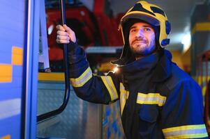 retrato do masculino bombeiro dentro uniforme às fogo estação foto