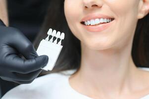 médico Coincidindo pacientes dentes cor com paleta, fechar-se. Cosmético odontologia foto