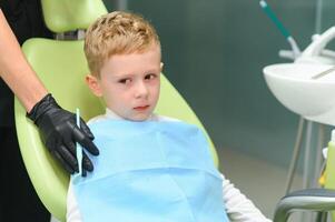 assustado ruivo Garoto chorando às recepção às dentista dentro dental cadeira. pediatra odontologia foto