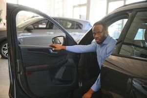 alegre Preto homem sentado dentro luxo automóvel, teste dirigir, transporte foto