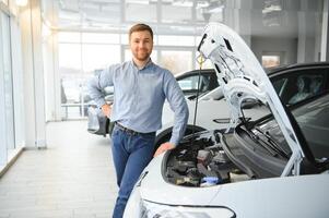 jovem homem, vendendo elétrico carros dentro a showroom. conceito do comprando ecológico carro para família foto