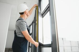 serviço homem instalando janela com Chave de fenda foto