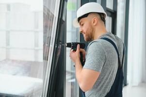 serviço homem instalando janela com Chave de fenda foto