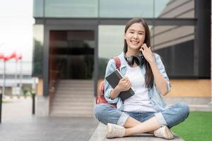 retrato lindo ásia mulher estudante. sorrir menina feliz estudar. ler livro dentro Faculdade campus. jovem fêmea em internacional Ásia universidade. Educação, estudar, escola, aprendizado, exame, continuar Educação foto