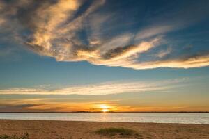 panorama do lindo pôr do sol com nuvens em a rota e então em a de praia com Palma árvores por aí foto