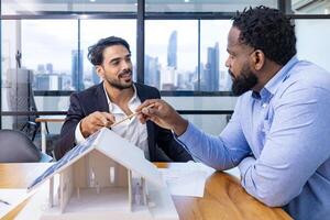 equipe do arquitetura e empresários estão discutindo e debate em chão plano modificação para real Estado investimento e habitação desenvolvimento projeto foto