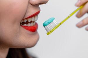 uma mulher é escovar dela dentes com uma escova de dente foto
