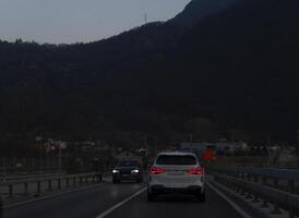 uma carro dirigindo em uma rodovia com montanhas dentro a fundo foto